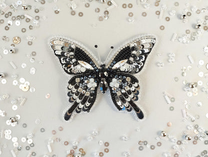 a black and white butterfly brooch sitting on top of a table