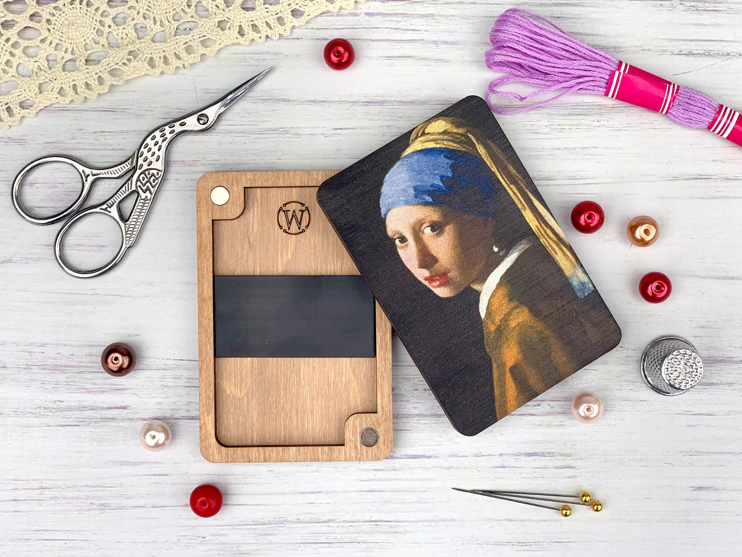 a picture of a girl with a pearl earring next to a pair of scissors