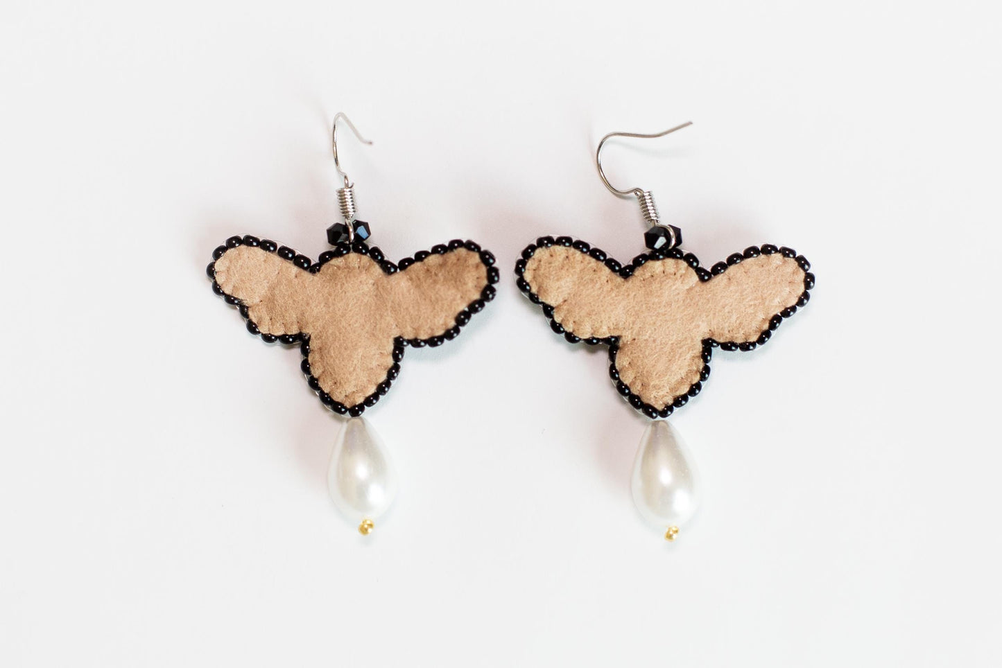 a pair of earrings with a heart and a pearl