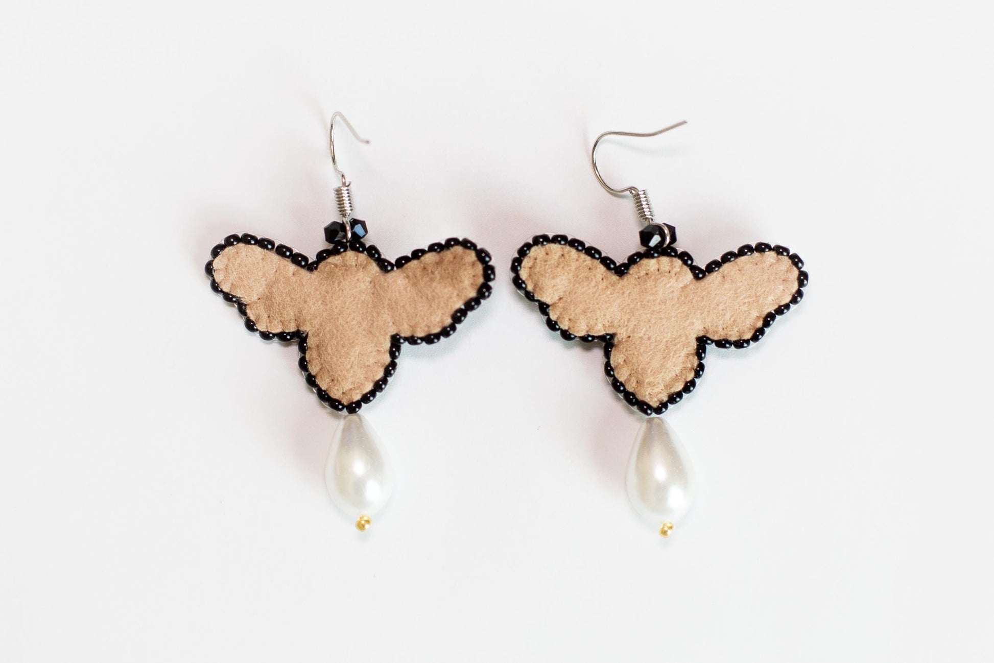 a pair of earrings with a heart and a pearl