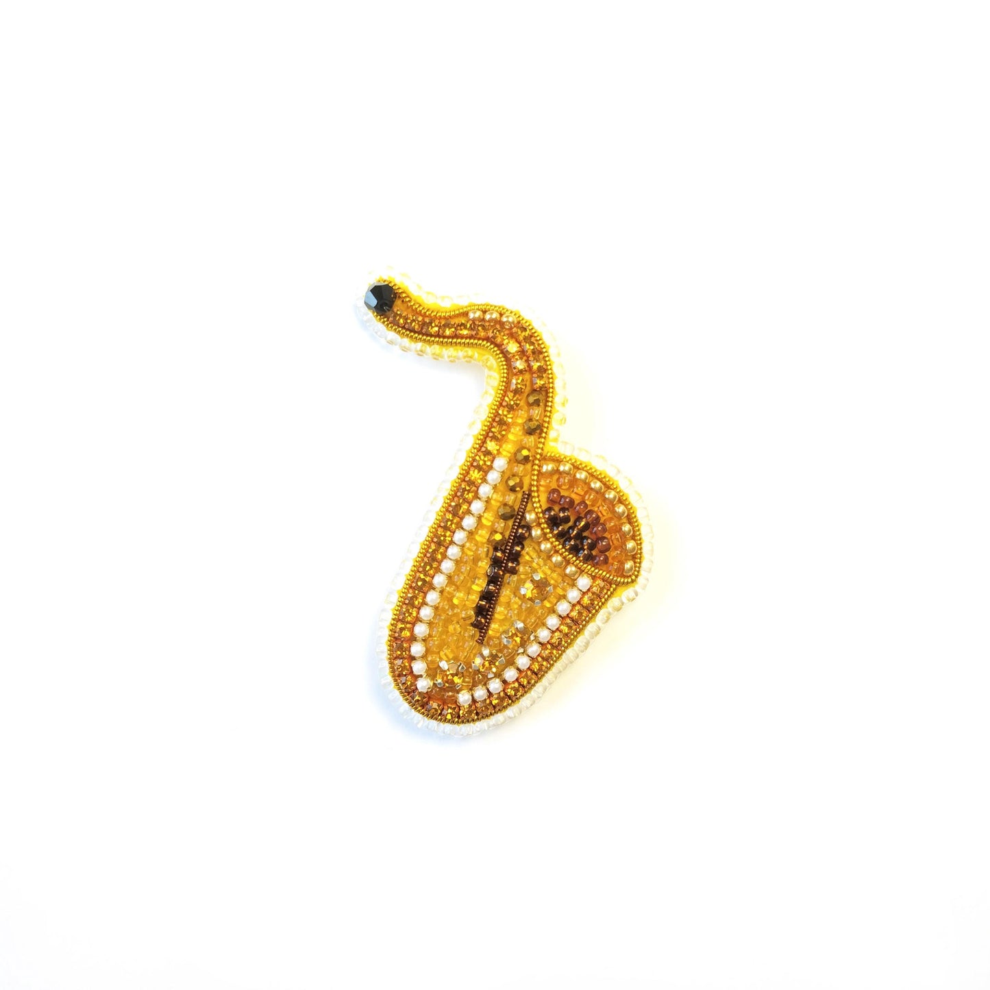 A gold-colored bead or ornament resembling a saxophone is shown against a white background.