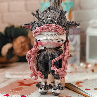 a crocheted cow with a scarf around its neck