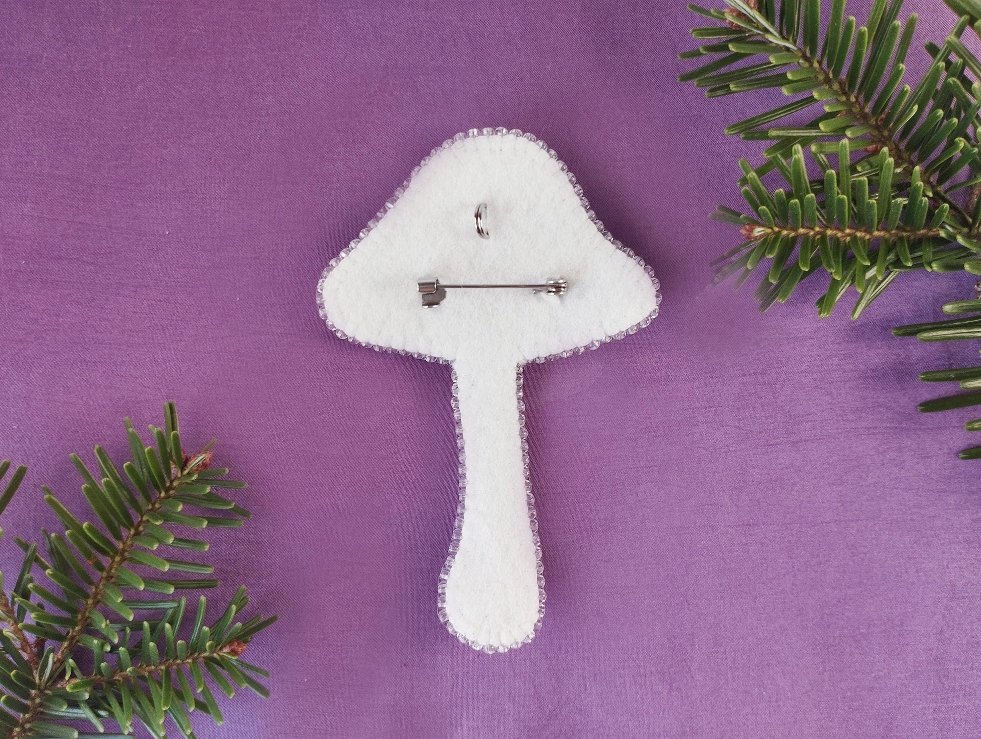a felt mushroom ornament on a purple background