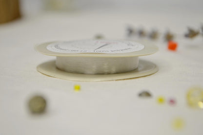 a spool of white thread sitting on top of a table
