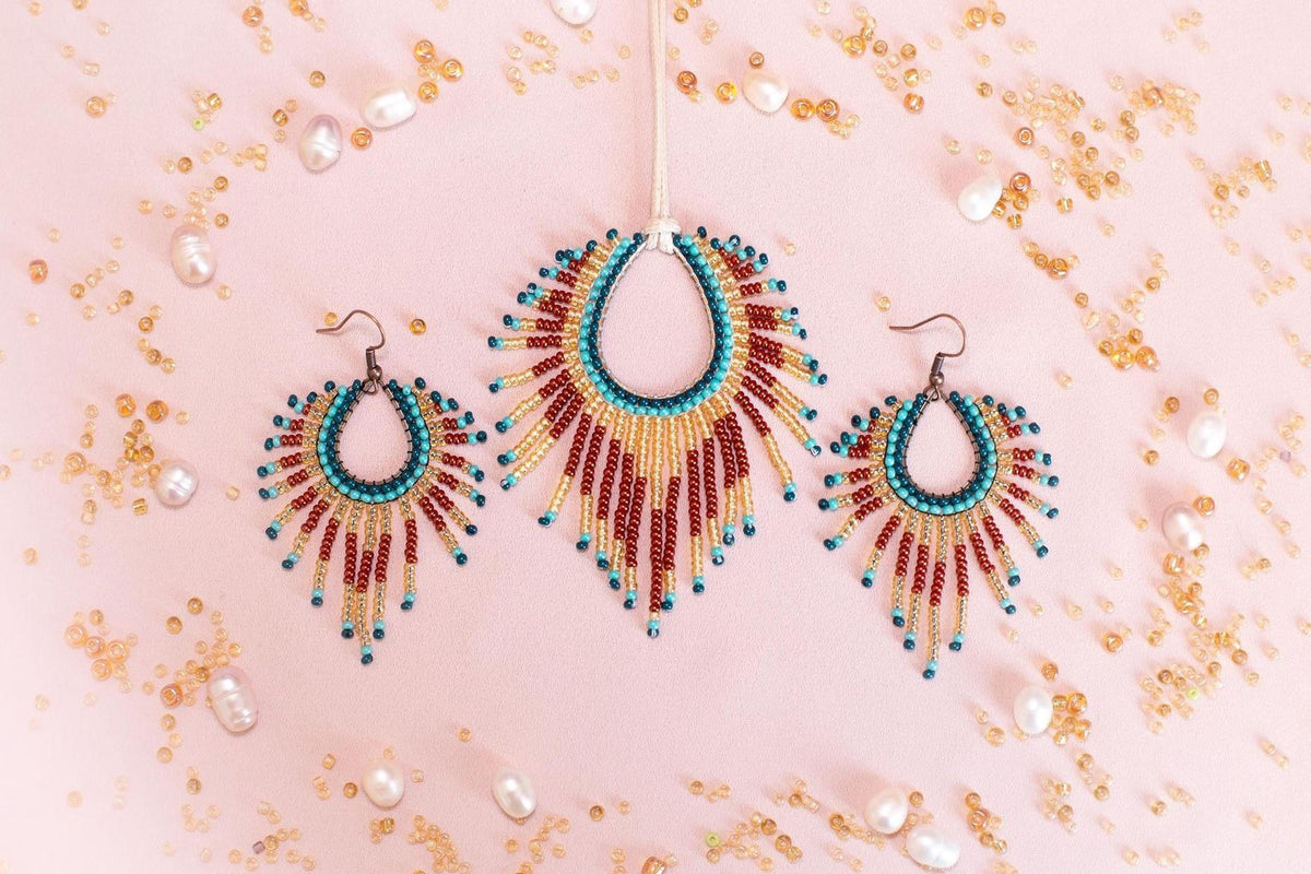 a set of beaded jewelry, including earrings and a necklace, arranged on a pink background with scattered pearls and beads.