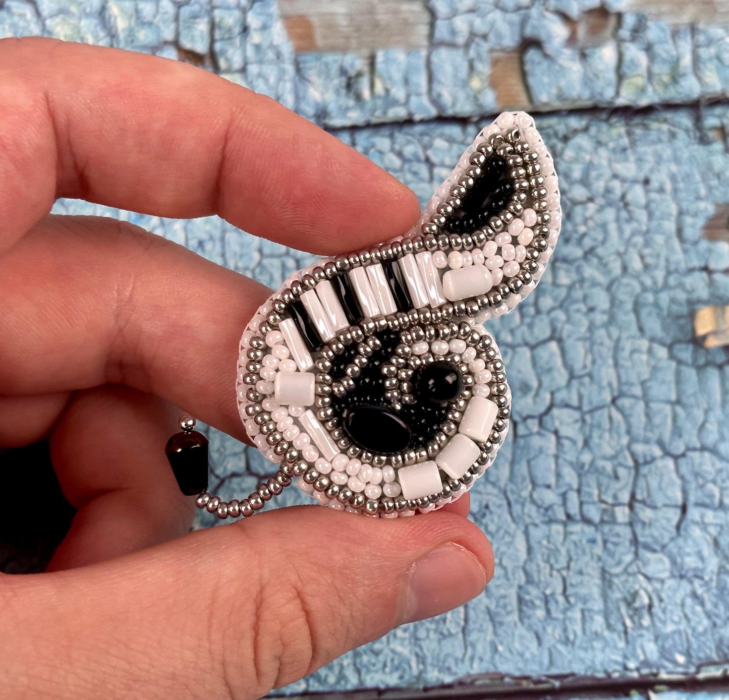 a person is holding a brooch with a music note on it