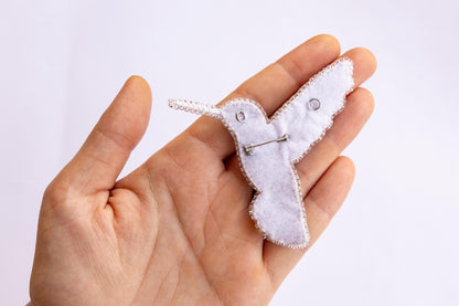 a person holding a tiny white bird in their hand