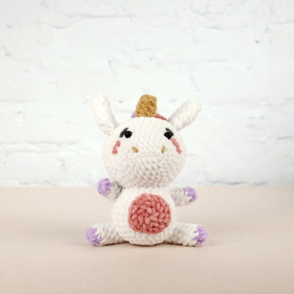 a crocheted white unicorn with a pink heart