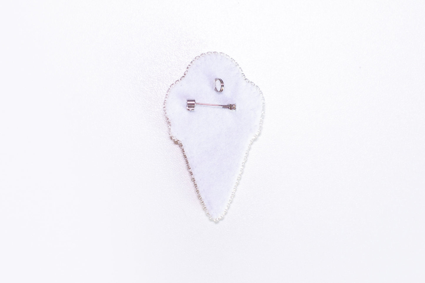 a white piece of cloth with a pin on it