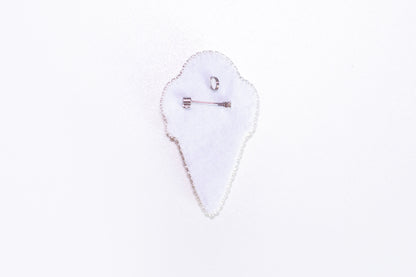 a white piece of cloth with a pin on it