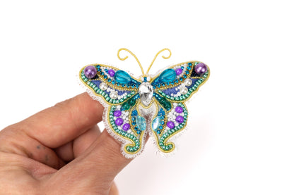 a butterfly brooch is being held in a person&#39;s hand