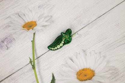 a green insect sitting on top of a white daisy