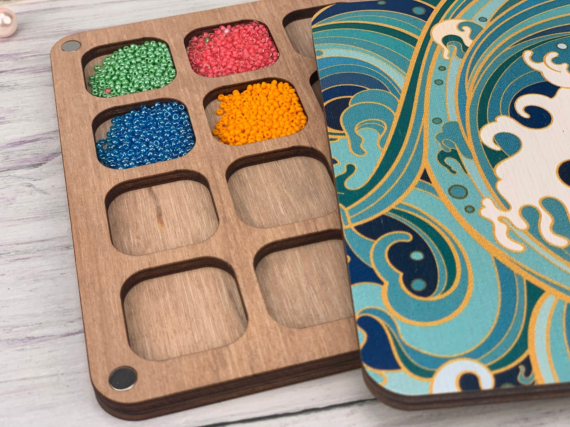 a wooden tray with beads in it on a table
