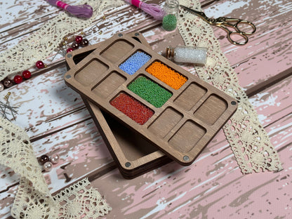 a wooden box filled with different colored beads
