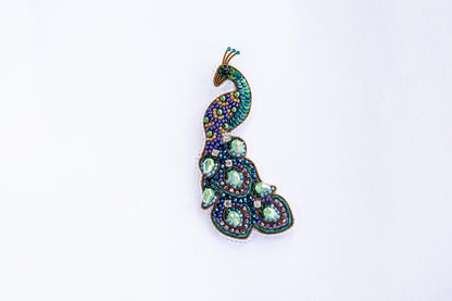 a brooch with a peacock design on it