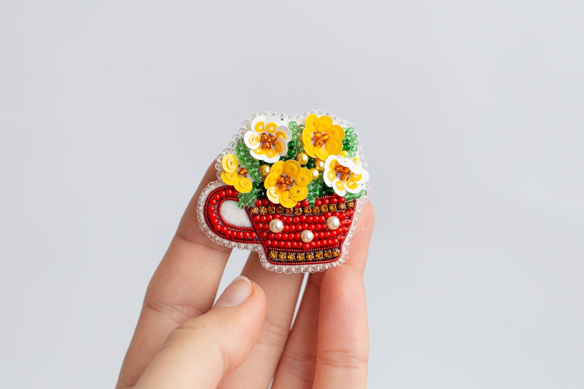 a hand holding a red car with flowers in it