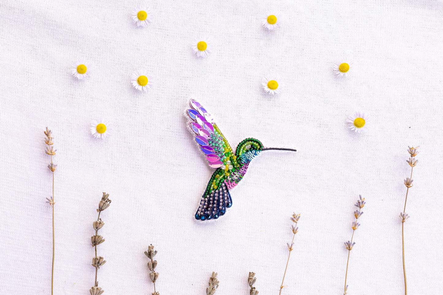 a colorful hummingbird flying over a field of flowers
