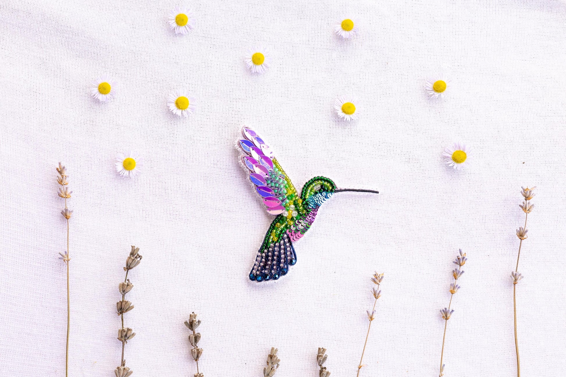 a colorful hummingbird flying over a field of flowers