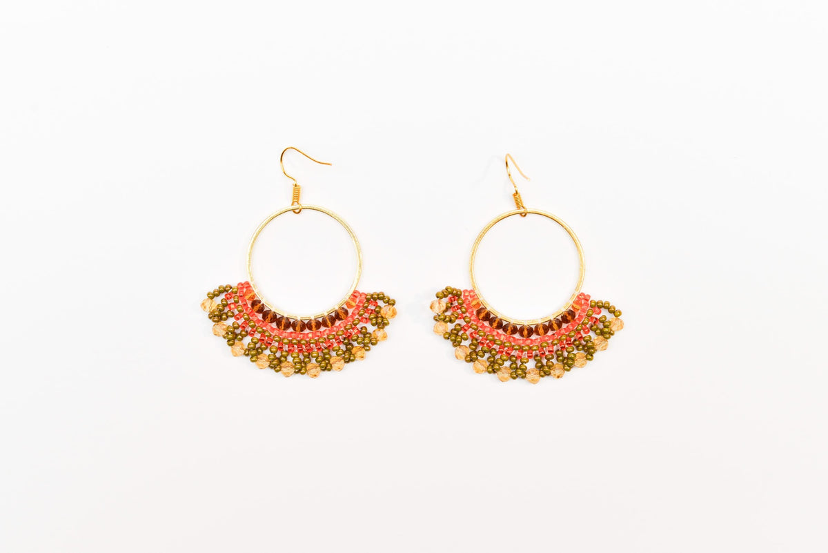 A pair of gold hoop earrings with colorful beaded designs.
