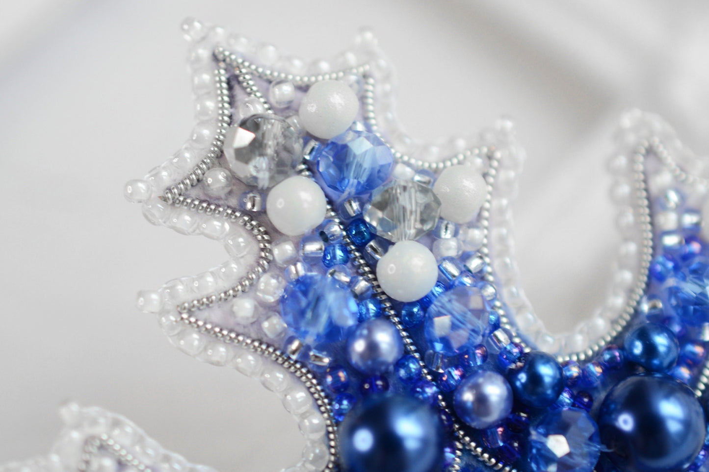 a close up of a blue and white beaded crown