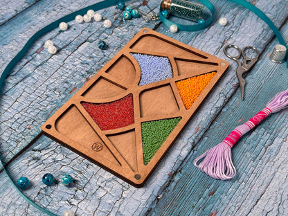 a wooden tray with a tassel and beads on a table