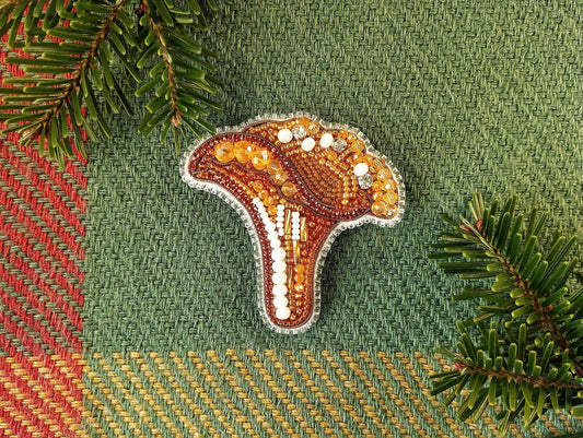 a beaded brooch sitting on top of a green surface