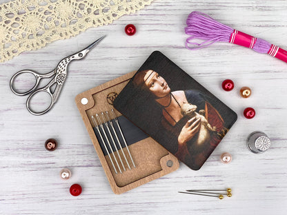 a pair of scissors, a pair of knitting needles, and a picture of a