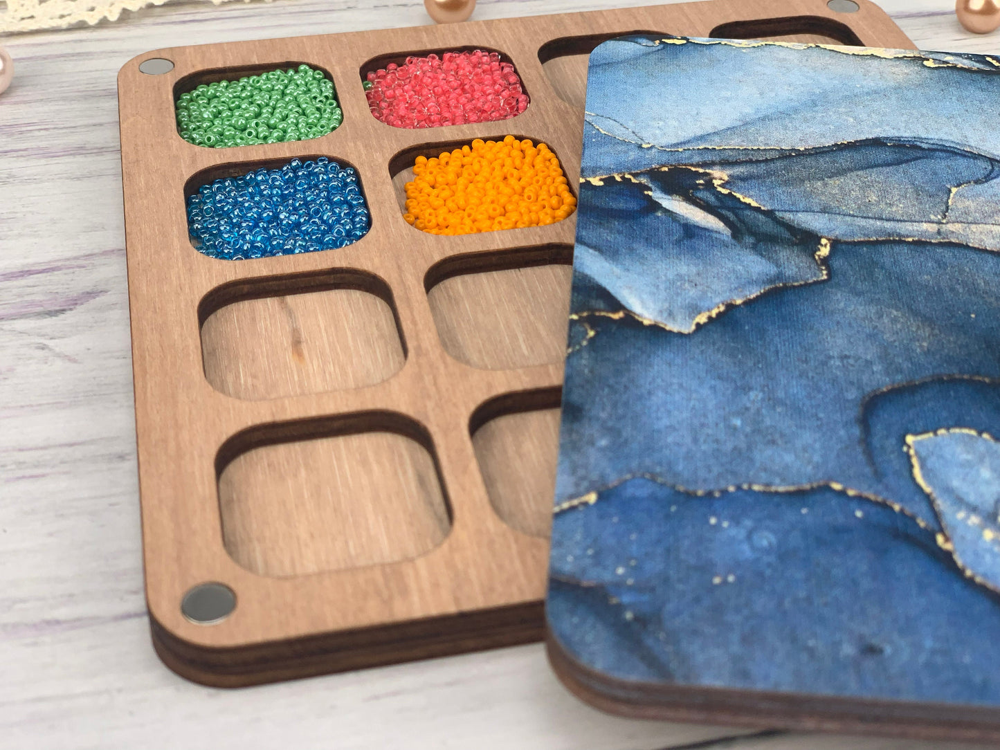 a wooden tray with different colored beads in it
