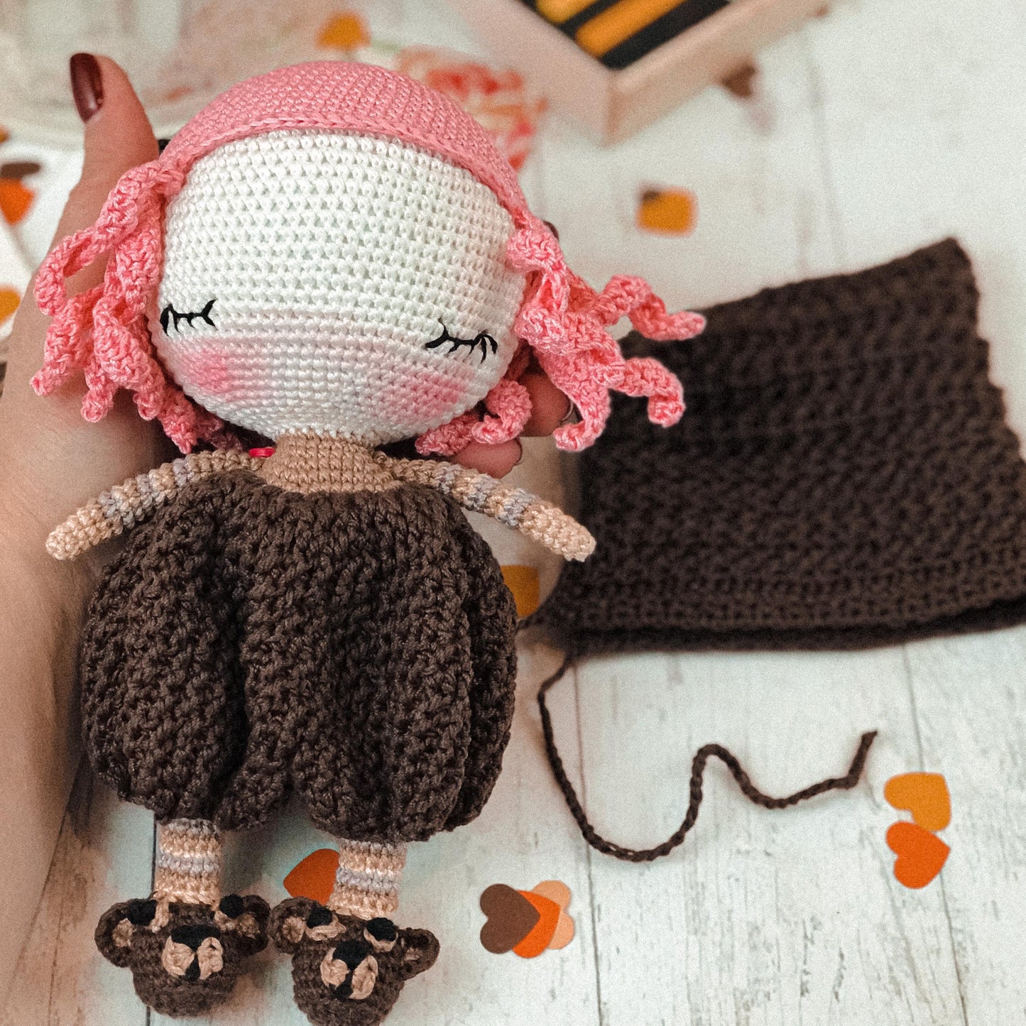 a crocheted doll is laying on a table