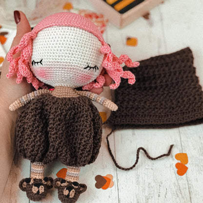 a crocheted doll is laying on a table