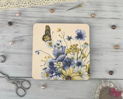 a picture of flowers and a butterfly on a coaster