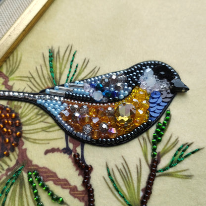 a detailed embroidered bird, with various beads and sequins adorning its feathers and body.