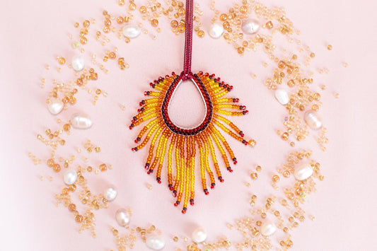 a necklace made of beads and pearls on a pink background