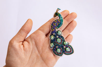 a person is holding a brooch in their hand