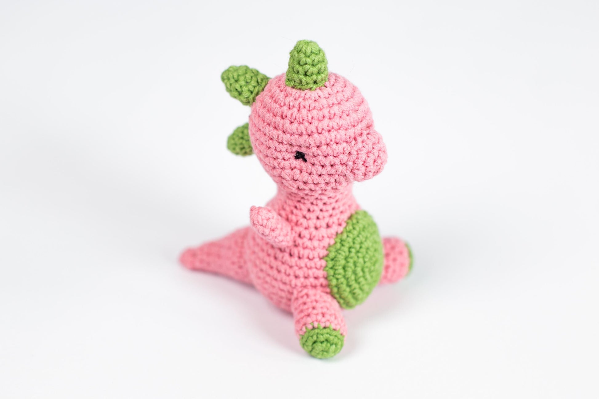 a crocheted pink and green stuffed animal