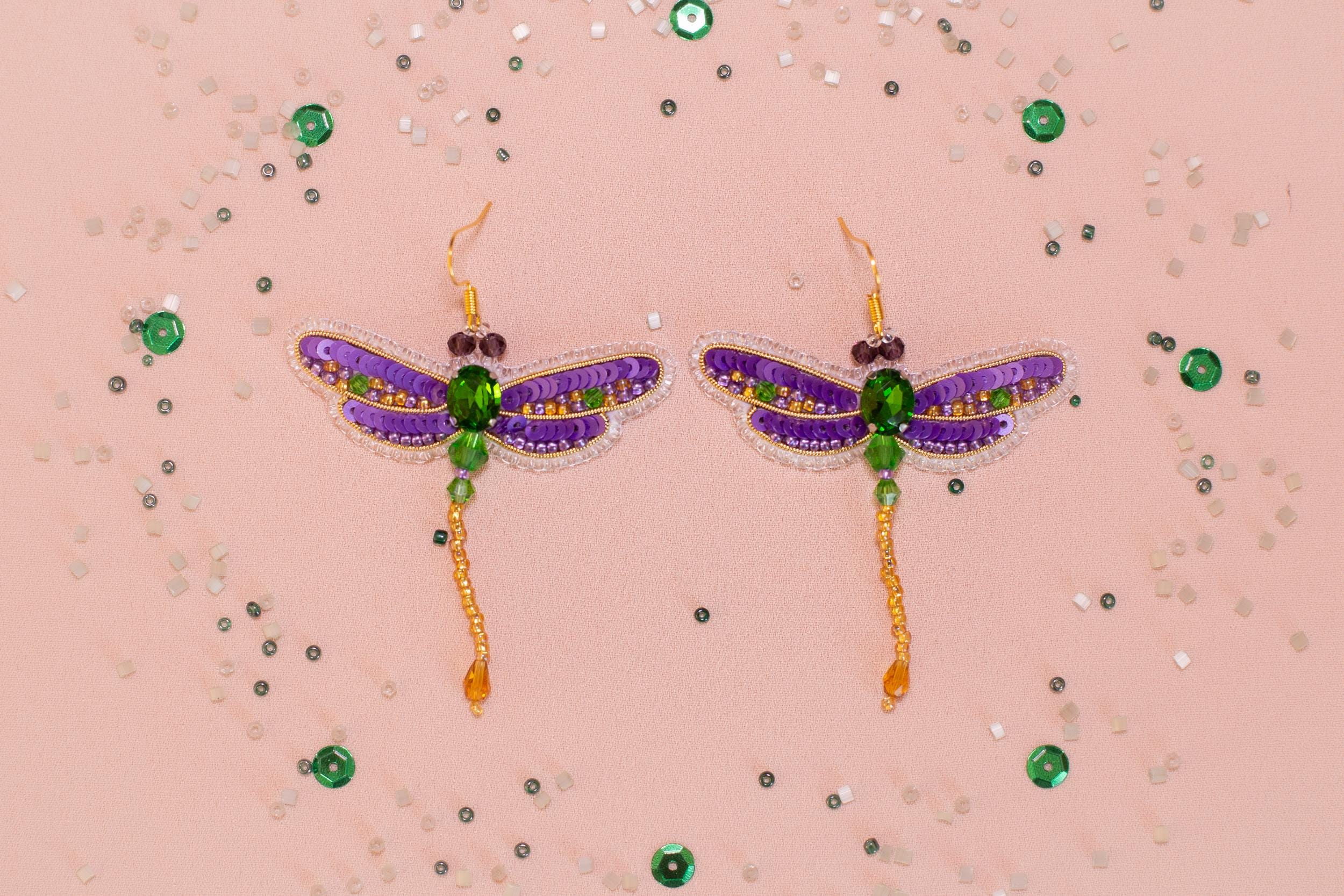 a pair of purple and green dragonfly earrings