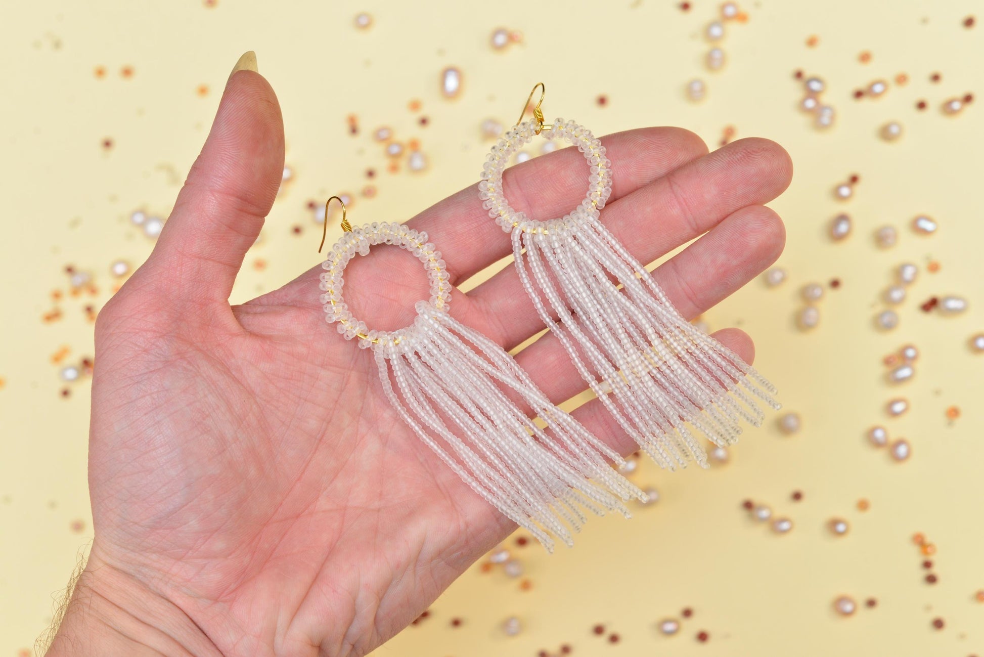 a hand is holding a pair of earrings