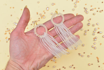 a hand is holding a pair of earrings