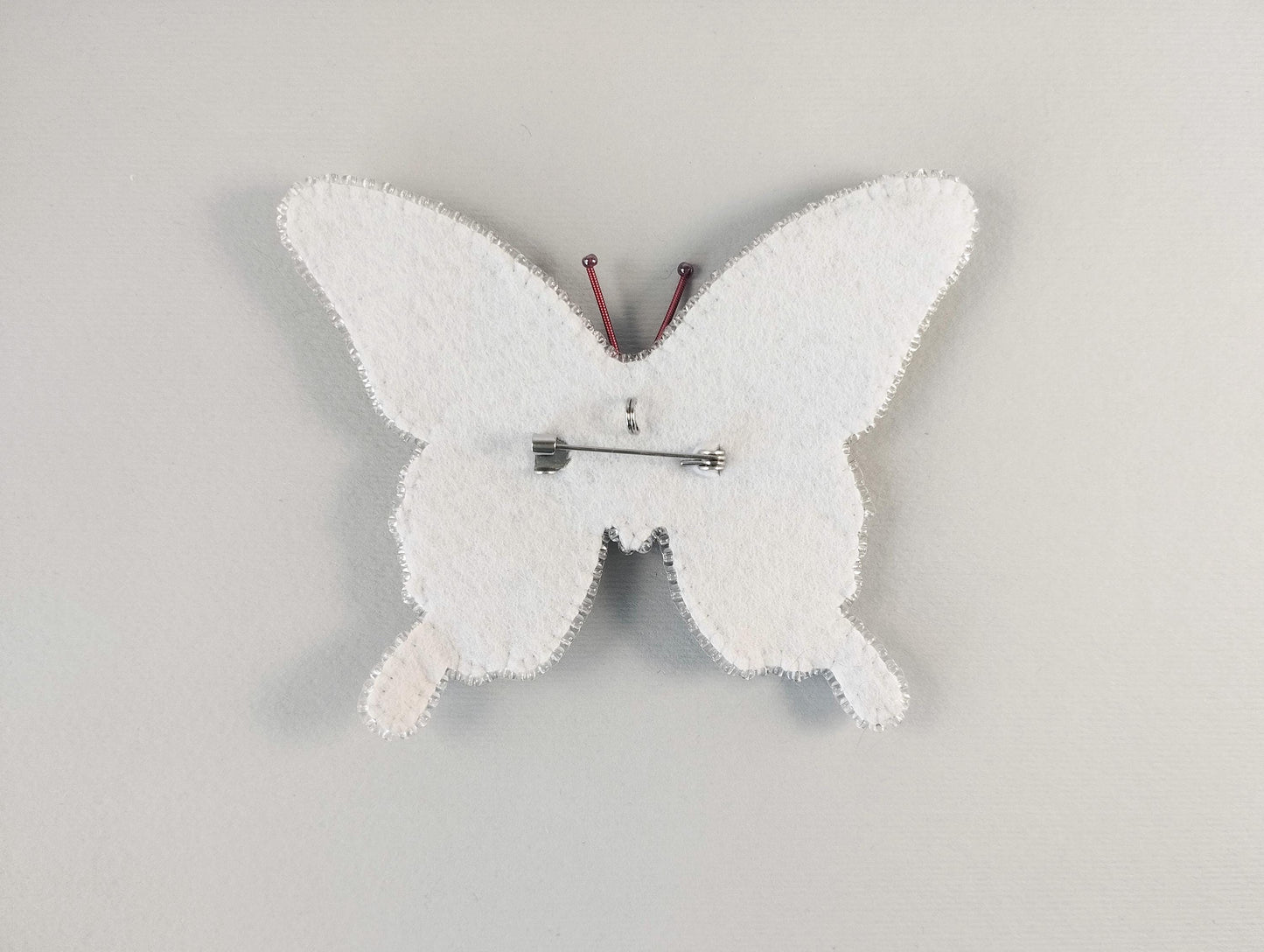a white clock with a butterfly design on it