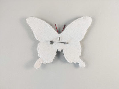 a white clock with a butterfly design on it