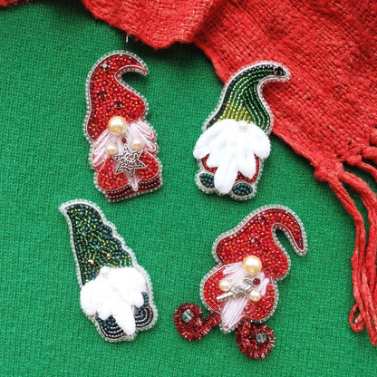 four decorative Christmas ornaments, each with a unique design and color scheme, arranged on a green background.