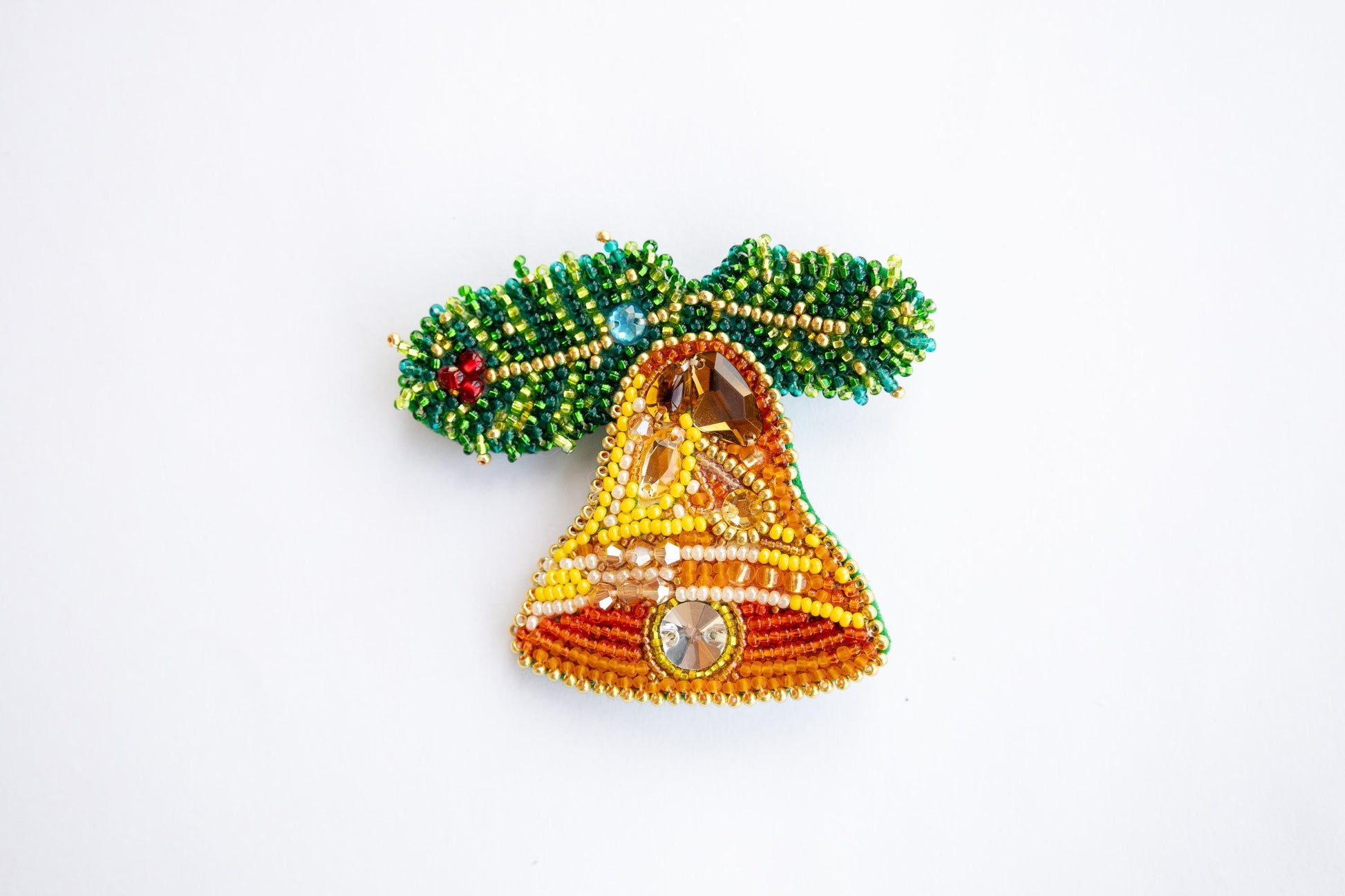 a beaded bell with a tree on top of it