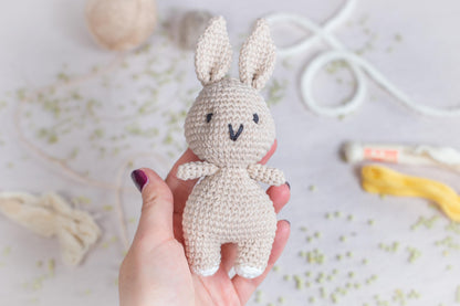 a hand holding a small crocheted bunny