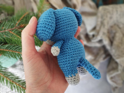 a hand holding a small crocheted stuffed animal