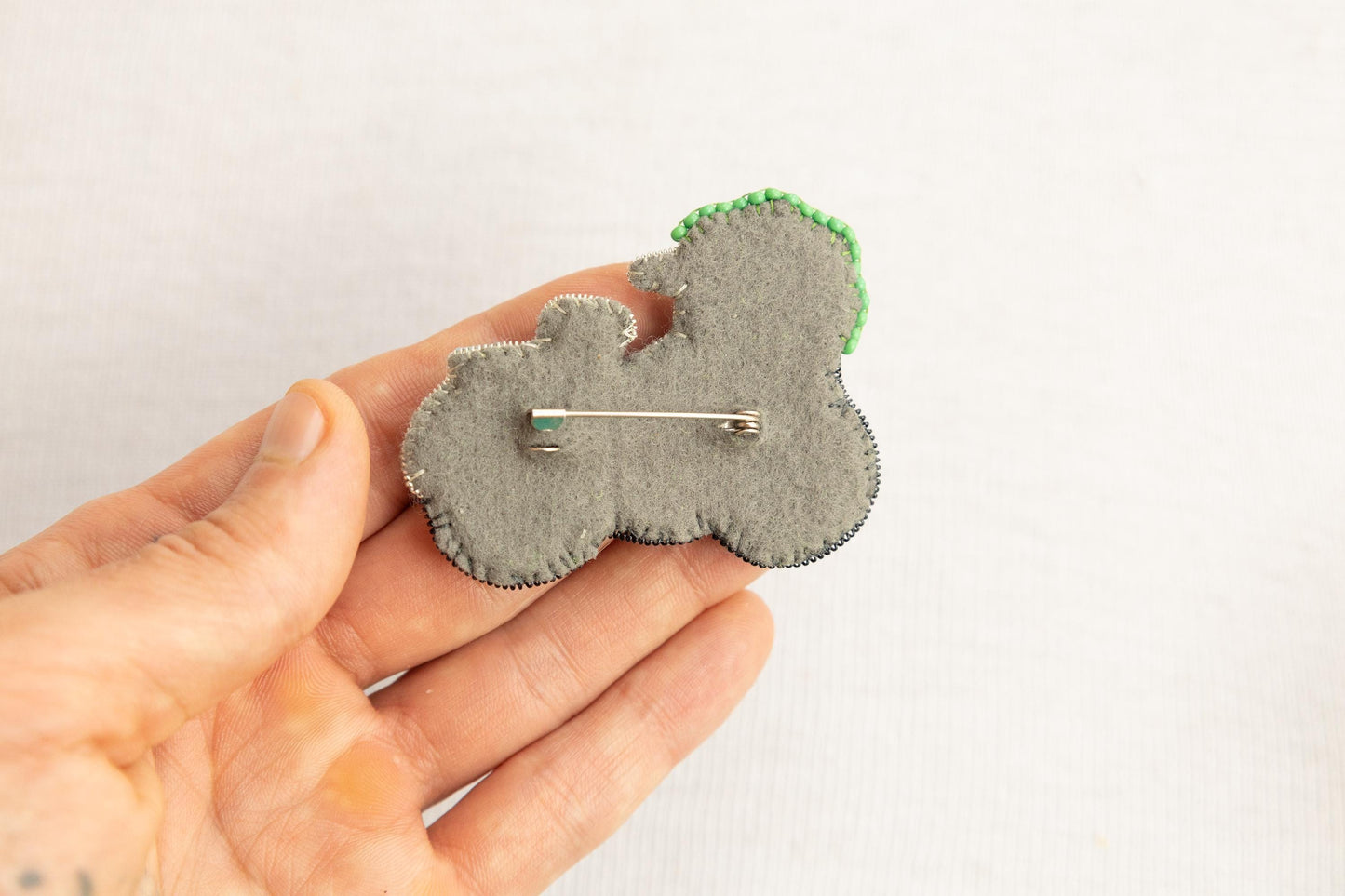 a person is holding a brooch in their hand