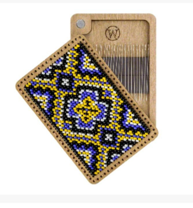 a wooden comb with a beaded design on it