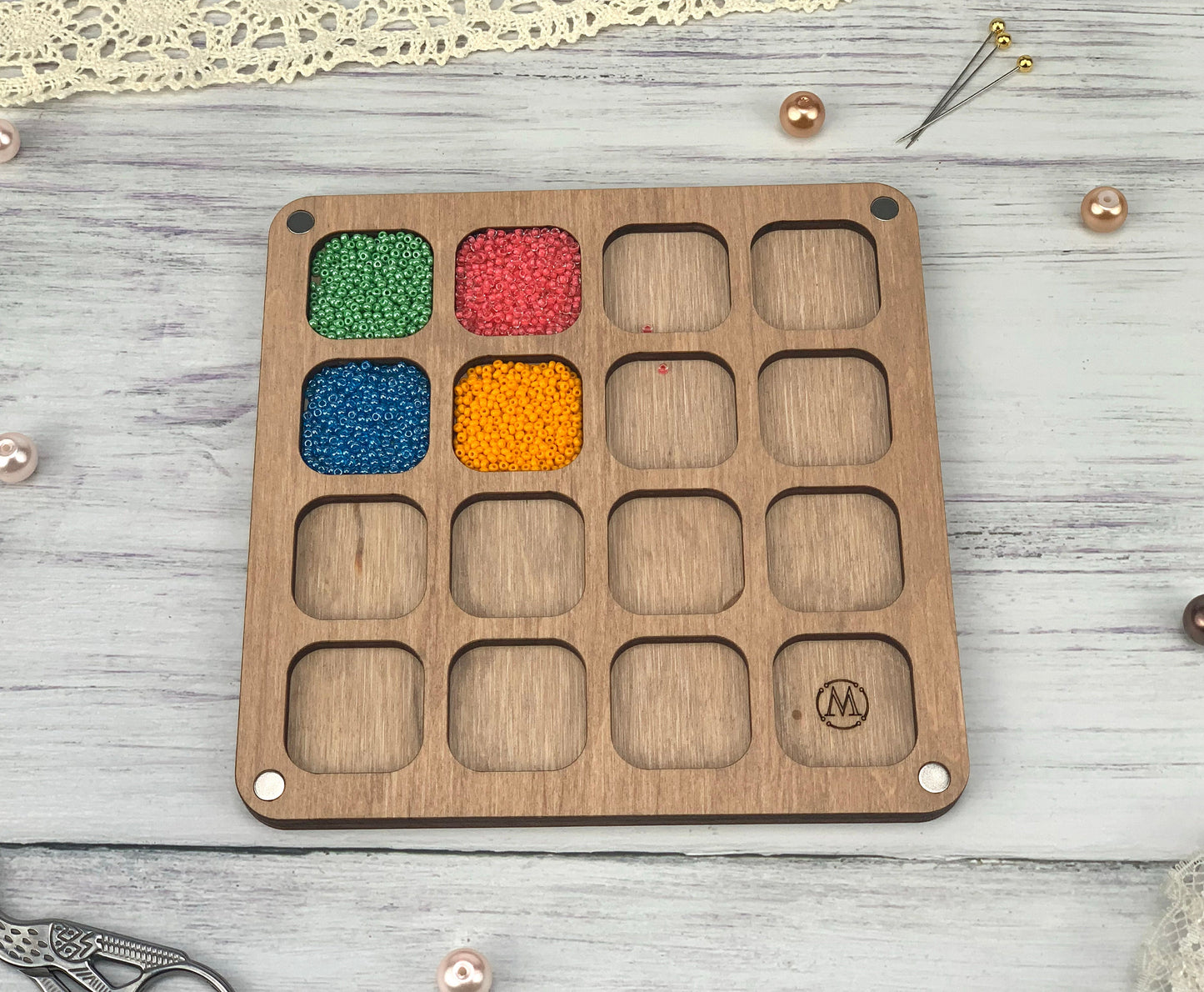 a wooden tray with beads and beads in it
