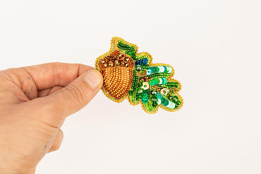 a person is holding a brooch in their hand