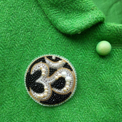 a close-up of a green fabric with a decorative brooch in the center.