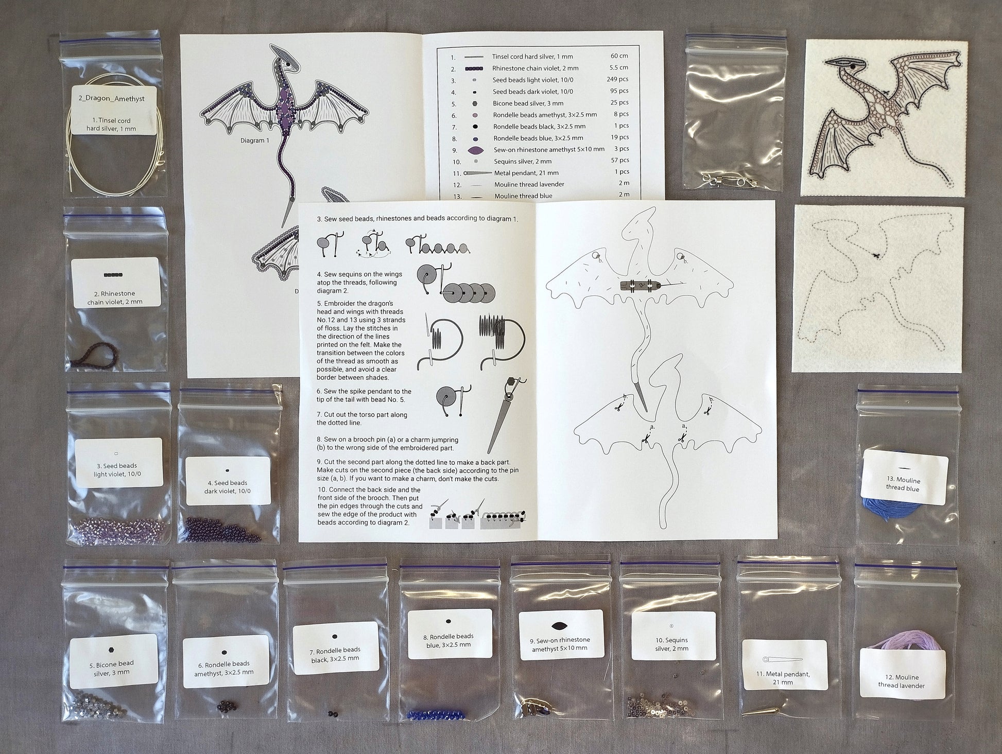 various sewing supplies and materials, including a diagram of a dragon, instructions, and several packages of beads and threads.